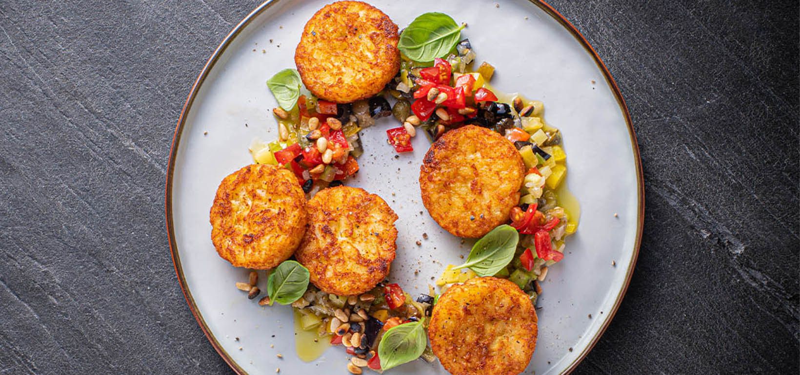 Pannil praetud Rösti kartulipannkoogid serveeritud Sitsiilia caponataga