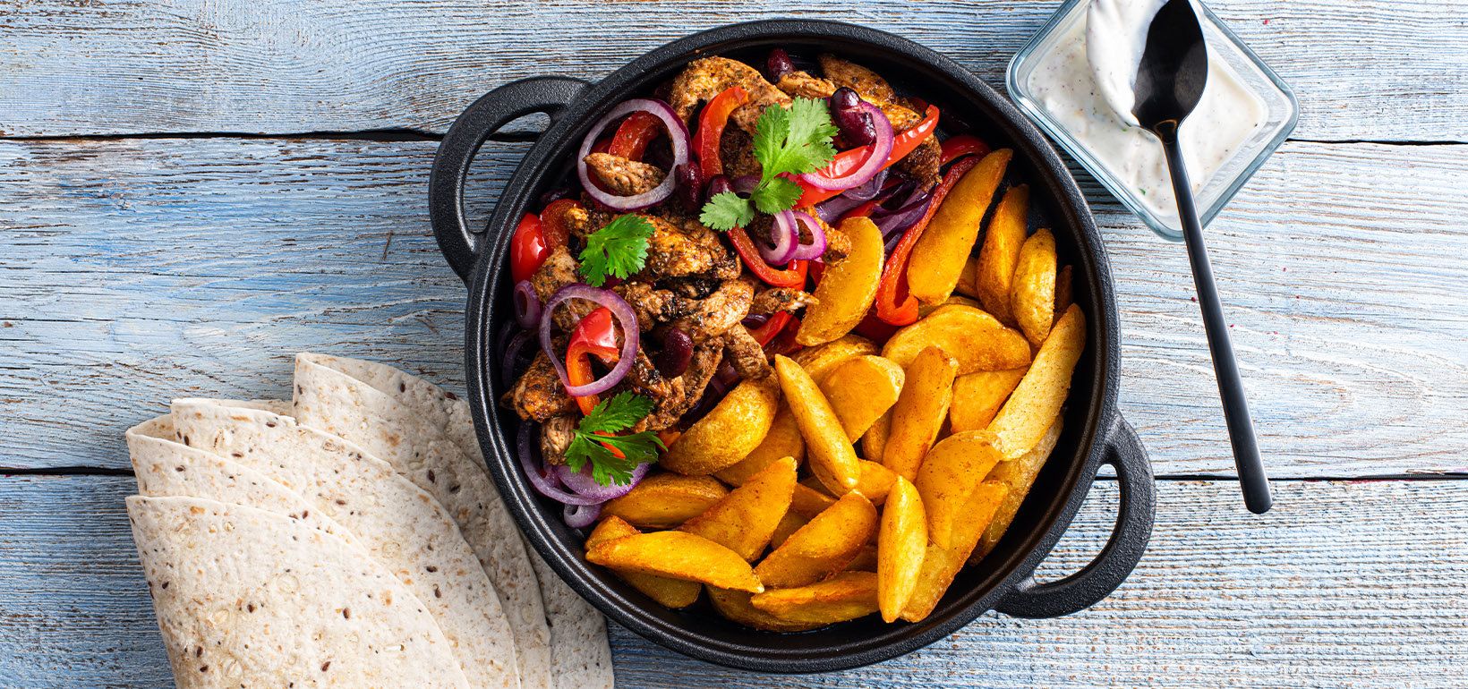 Fajitas kana, paprika, punase sibula, jogurti ja ubadega serveeritud Pati Parts Tex Mex kartulilõik