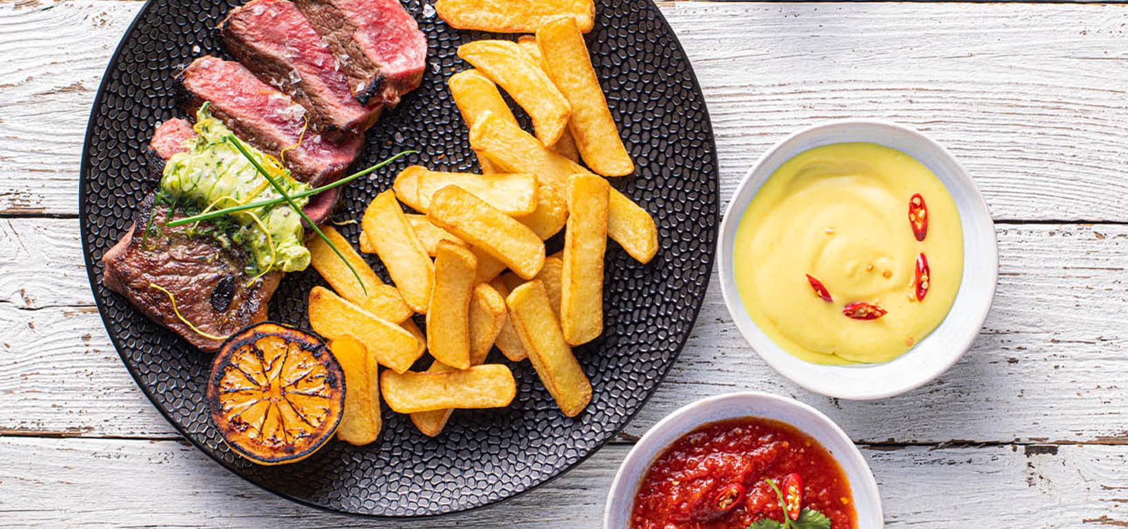 Grillitud antrekoot serveeritud Steak Fries friikartulite ja omatehtud kastmetega